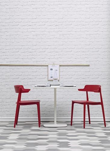 Twee rode houten Nemea stoelen aan een witte tafel van het merk Pedrali