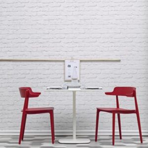 Twee rode houten Nemea stoelen aan een witte tafel van het merk Pedrali